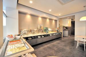 a restaurant kitchen with a counter with food at Astron Suites & Apartments in Kos