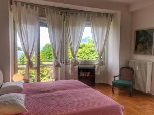 een slaapkamer met een bed en een groot raam bij Bella in Stresa