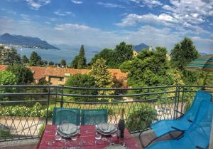 een patio met een tafel en stoelen op een balkon bij Bella in Stresa