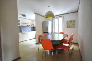 a kitchen with a dining room table and orange chairs at Jungfrau Family Holiday Home in Matten