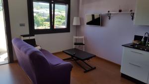 sala de estar con sofá púrpura y mesa en Casa Rural Oscar, en Baiona