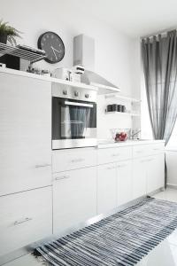 a kitchen with white cabinets and a clock on the wall at Sole e mare in Órmos