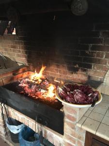 a grill with a plate of meat on fire at La Ginestra in Castel San Lorenzo