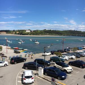 a parking lot with cars parked next to a body of water at Garelly 2 in San Vicente de la Barquera