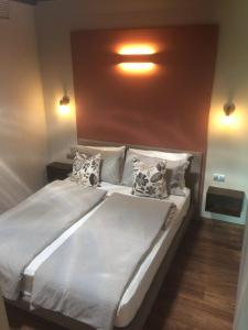1 dormitorio con 1 cama blanca grande con almohadas en Energaia, en Toscolano Maderno