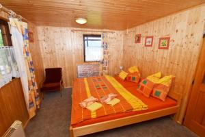 a bedroom with a bed in a wooden room at Lesní pension in Lipno nad Vltavou