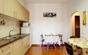 een keuken met een wastafel en een tafel in een kamer bij Alojamentos Oasis in Mértola