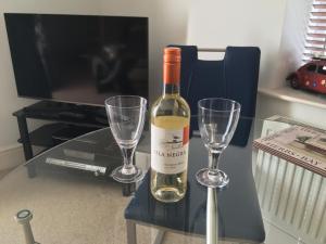 a bottle of wine and two wine glasses on a table at Southover Beach in Woolacombe