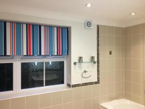 a bathroom with a window and a tub and a sink at Southover Beach in Woolacombe +98 photos