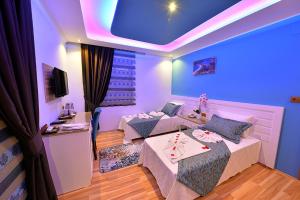 ein Hotelzimmer mit 2 Betten und blauer Decke in der Unterkunft Kayı Hotel in Fethiye