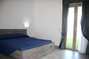 a bedroom with a bed with blue sheets and a window at Il Borgo in Castelsardo
