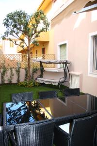 a patio with chairs and a hammock and a tree at Il Borgo in Castelsardo