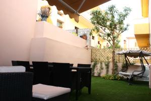patio con sedie, ombrellone ed erba di Il Borgo a Castelsardo