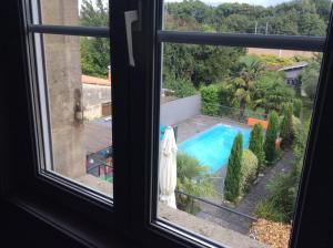 Elle offre une vue sur la piscine depuis sa fenêtre. dans l'établissement Maison (villa) de charme avec piscine, à Carbon-Blanc