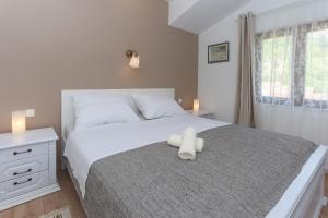 a white teddy bear sitting on top of a bed at Waterfall House Getaway in Trilj