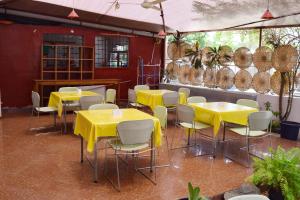 ein Esszimmer mit gelben Tischen und Stühlen in der Unterkunft Hotel Saint-Jean in Cotonou