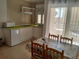 a kitchen with a table and chairs and a kitchen with a window at ApartRoquetas in Roquetas de Mar