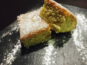 a piece of cake on a plate with powdered sugar at Hotel Dom in Organyà