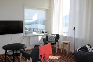 a living room with chairs and a tv and a window at RIBO Apartment Riksgränsen in Riksgränsen