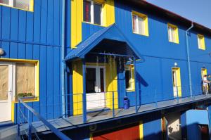 a colorful building with a reflection in the water at Hostel Stozhary in Ternopilʼ