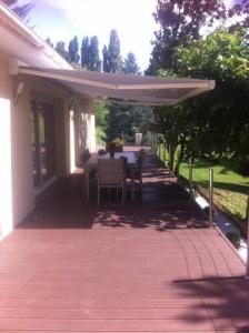 a patio with a table and an umbrella at le jardin d Eau in Lamothe-Montravel