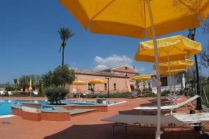 a pool with tables and yellow umbrellas and chairs at Agriturismo La Casa Di Botro in Botricello