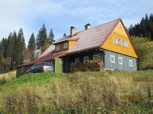 a yellow and blue house on top of a hill at Horská Chata U Básníka in Horní Malá Úpa