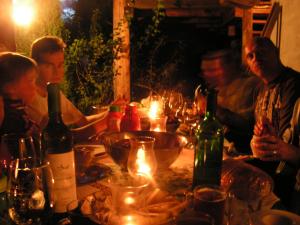 um grupo de pessoas sentadas à volta de uma mesa com garrafas de vinho em Winnica Na Leśnej Polanie em Zabór