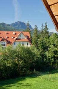a house with a red roof and some trees at Willa Magdalena in Zakopane