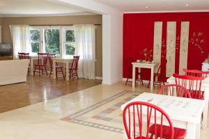 uma sala de jantar com paredes vermelhas e cadeiras vermelhas em Hosteria Mi Casa en la Sierra em Tandil