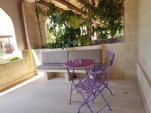 a chair and table in a room at Le Scuderie - Castello Monaci in Salice Salentino