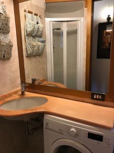 a bathroom with a sink and a mirror over a washing machine at Appartamento chic Riomaggiore 5 Terre in Riomaggiore