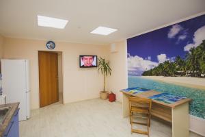 a kitchen with a desk and a painting of the beach at Tortuga in Tyumen