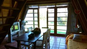 a room with a table and a bed and a window at Tierra Mandarina Cabañas in Gualeguaychú