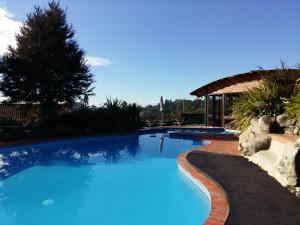 a swimming pool with blue water in a yard at Kimi Ora Eco Resort in Kaiteriteri