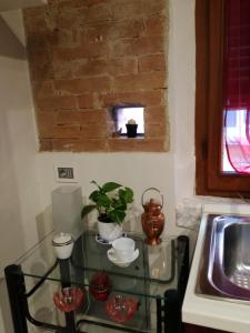 une table en verre dans une cuisine avec évier dans l'établissement Nonna Anna, à Sienne