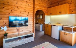 a kitchen with a wood paneled wall and a wood paneled ceiling at Kimi Ora Eco Resort in Kaiteriteri