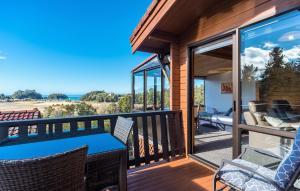 a deck with a table and chairs and a view of the ocean at Kimi Ora Eco Resort in Kaiteriteri