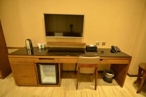 a desk with a phone and a television on top of it at eHome Hotel in Taoyuan