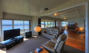 a living room with a couch and a flat screen tv at Stanley View Beach House in Stanley