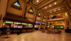 a lobby of a restaurant with people standing at a bar at Manuelsons Malabar Palace in Kozhikode