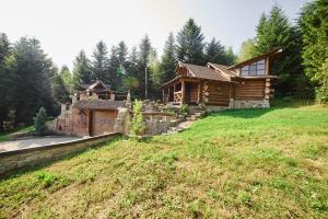 uma cabana de madeira no meio de um campo em Forest House exclusive em Skhidnitsa