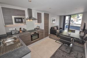 a kitchen and living room with a table and a couch at Dream Apartments St Thomas Hall in Belfast