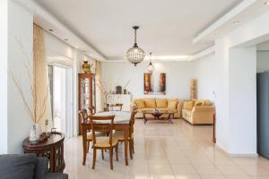 a living room with a couch and a table and chairs at MG House with Sea and Garden view in Korakiaí