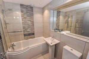 y baño con bañera, lavabo y aseo. en Dream Apartments St Thomas Hall, en Belfast