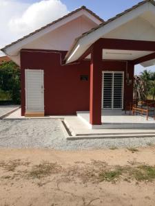 una pequeña casa con un rojo y blanco en Homestay AZMI ZITA, en Kuala Terengganu