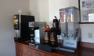a counter with a coffee maker and several bottles at Super 8 by Wyndham Colorado Springs Airport in Colorado Springs