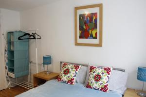ein Schlafzimmer mit einem blauen Bett und einem Bild an der Wand in der Unterkunft The Shop By Treetop Property in Cirencester