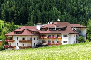 ein großes Haus auf einem Hügel in der Unterkunft Residence Garni Stella in St. Vigil