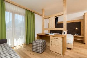 Schlafzimmer mit einem Schreibtisch und einem Etagenbett in der Unterkunft Residence Garni Stella in St. Vigil